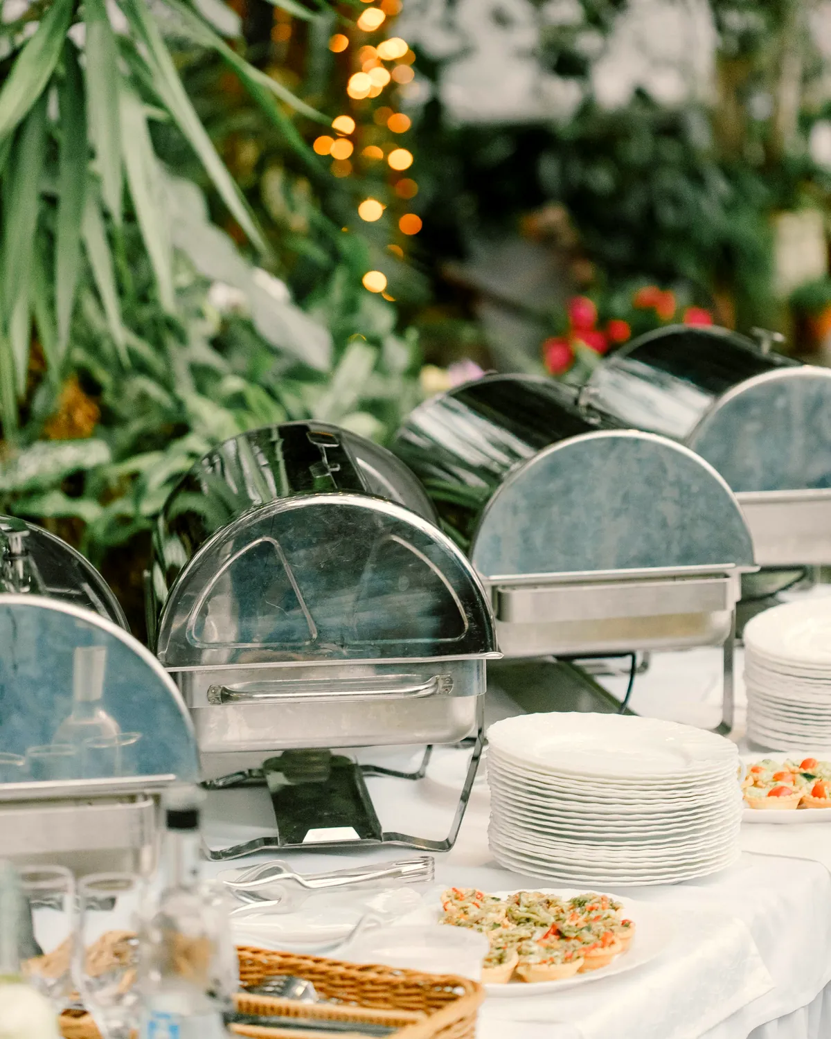 An outdoor buffet set with chafing dishes and plates