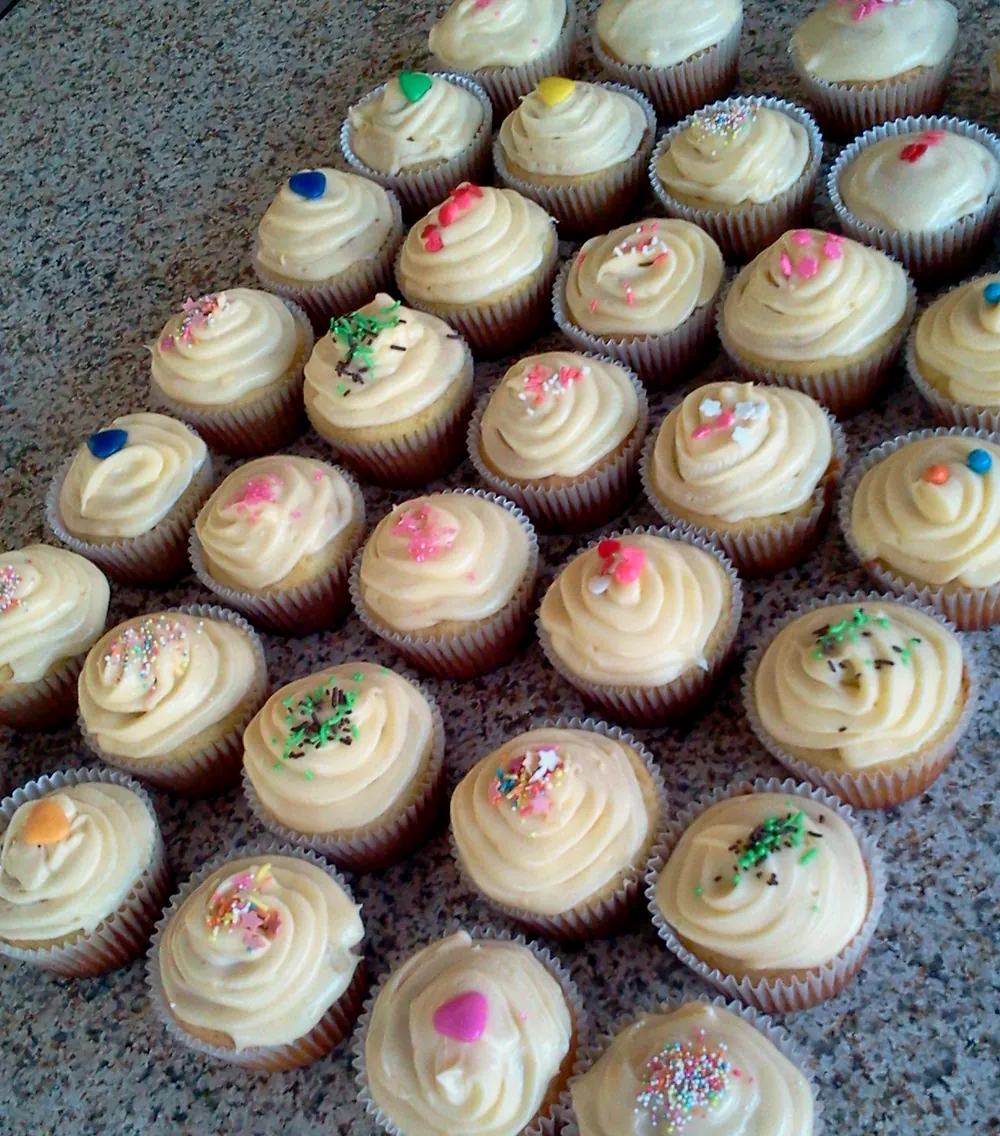 Rows of vanilla cupcakes with sprinkles